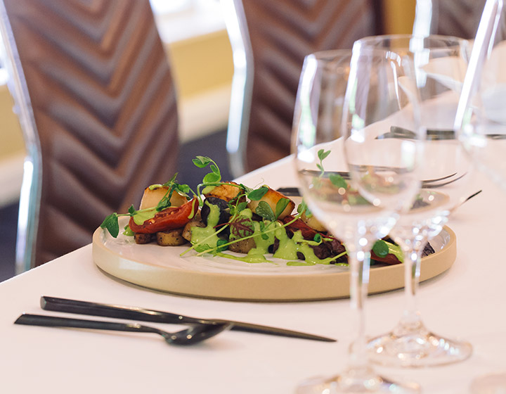 conference table dinner set up with single plate and wine glasses