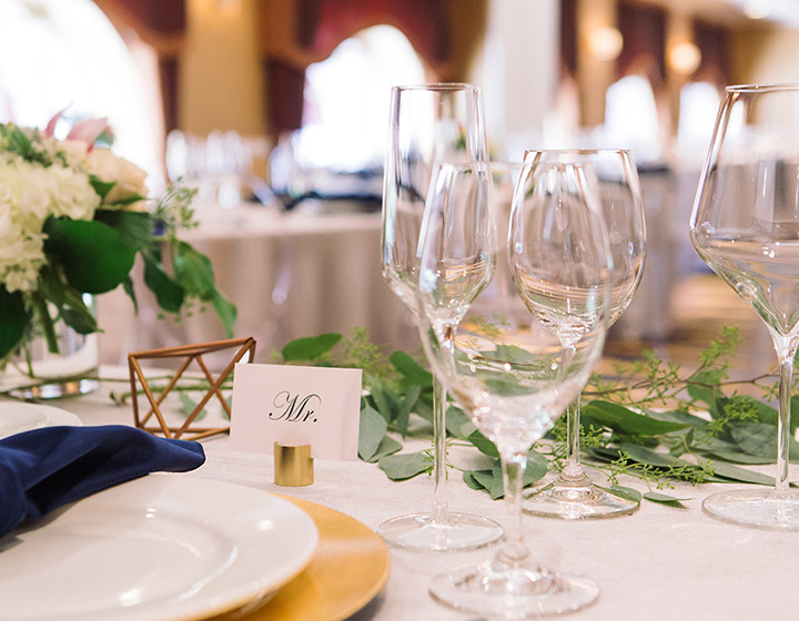 wedding round table set with wine glasses and floral arrangements